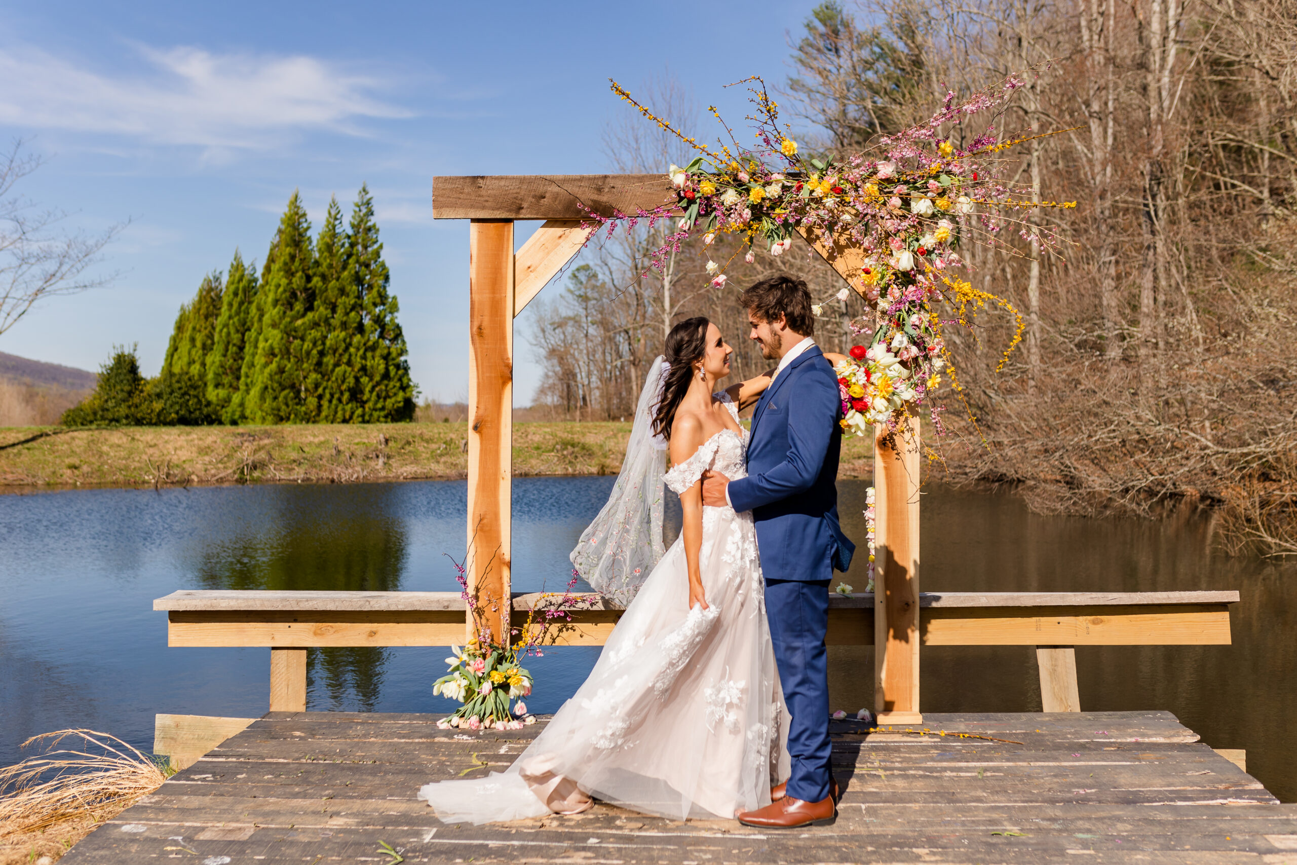 A bride and groom pose on a dock at Silver Fox Lavender Farm in Nellysford, VA.
